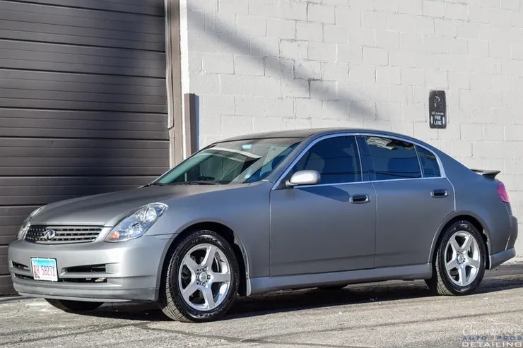 A silver car is parked in front of a garage door.