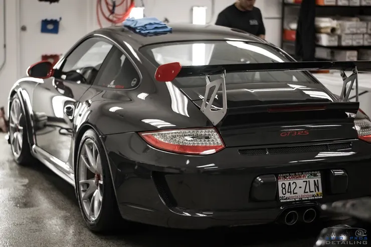 A black sports car with a license plate that says 842-zln