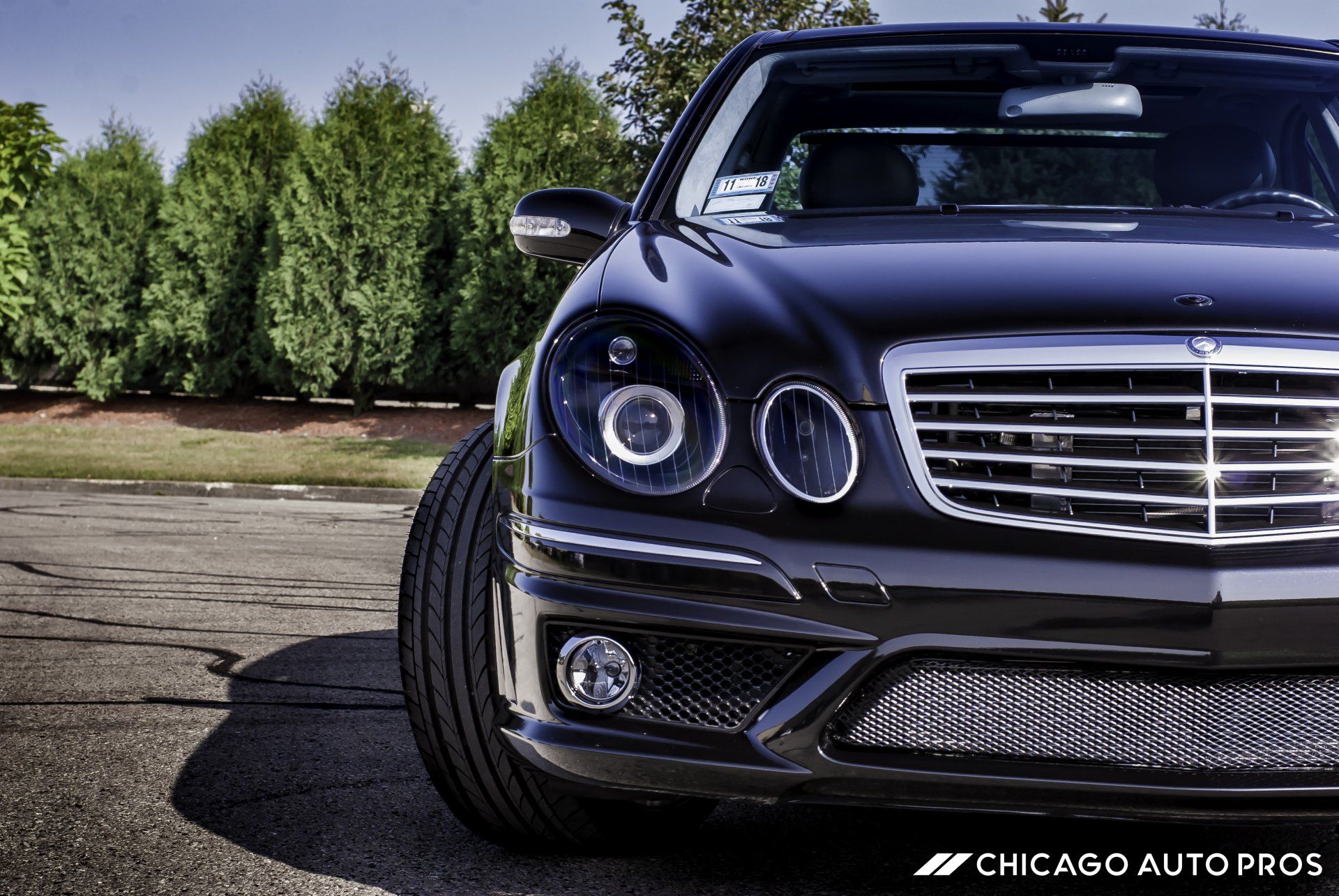 A black mercedes is parked on the side of the road