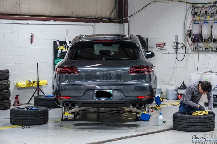 A man is working on a car in a garage.