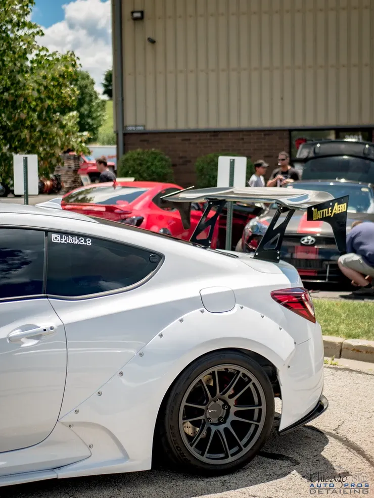 A white car is parked in front of a building.