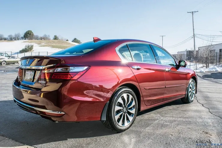 A red honda accord is parked in a parking lot.