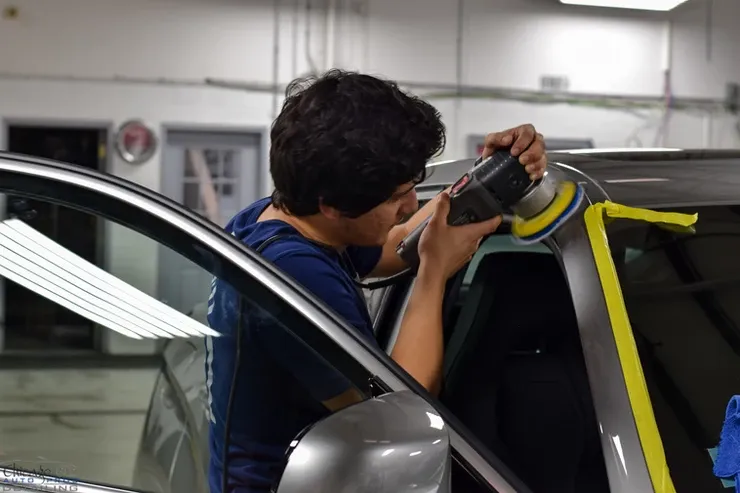 A man is polishing a car with a machine