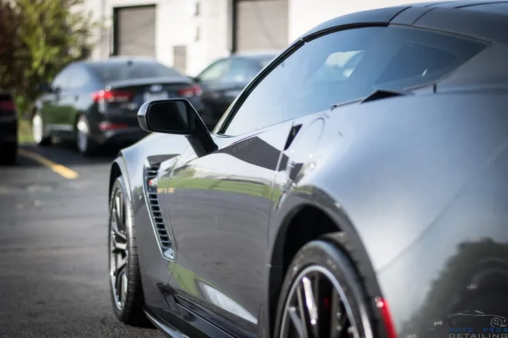A black sports car is parked in a parking lot.