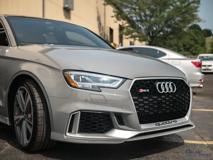 A silver audi rs3 is parked in a parking lot.