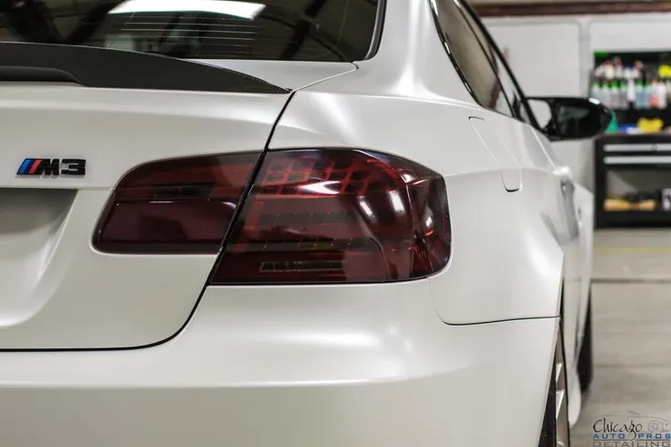 A white bmw m3 is parked in a garage.