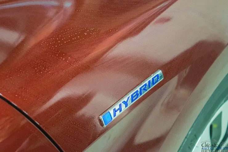 A close up of a hybrid badge on the side of a car