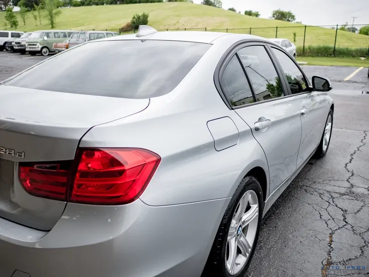 A silver bmw is parked in a parking lot.