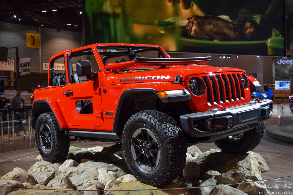 A red jeep wrangler is on display at a car show.