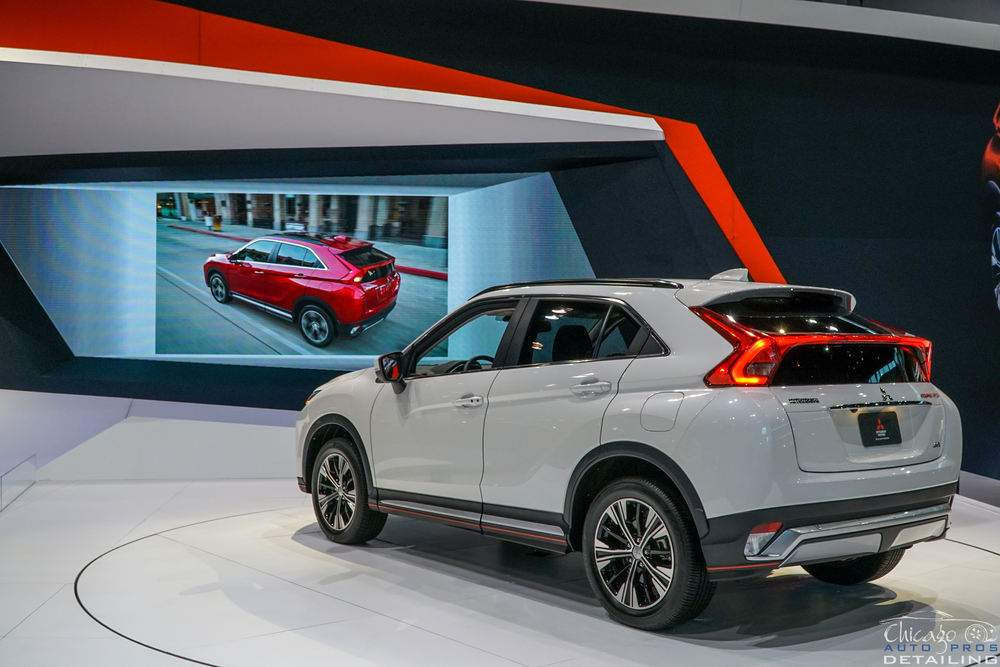 A white mitsubishi eclipse cross is on display at a car show.