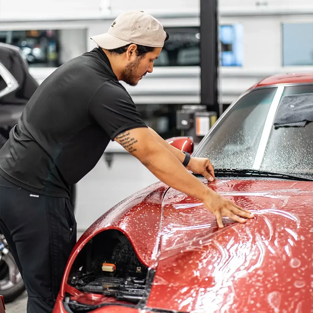 a man is cleaning the windows of a car at chicago auto pros .