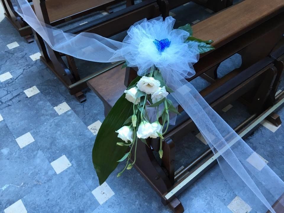 Composizione di fiori bianchi su banco di una chiesa