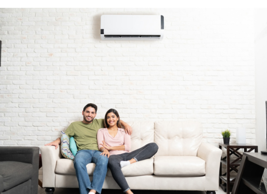 Satisfied Denver couple sitting on the couch, enjoying comfortable home after heat pump replacement