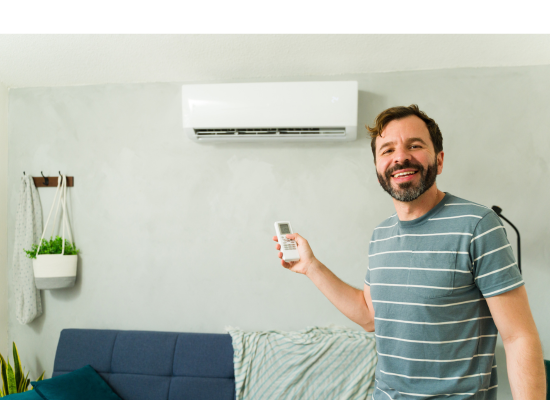 Happy homeowner holding the remote to his new ductless mini split heat pump in his Denver home
