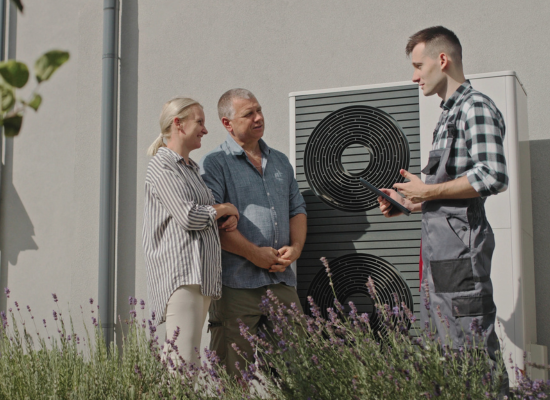 Denver Heat Pump Pros technician explaining the features of a new heat pump system to couple