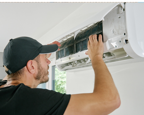 Heat Pump Pros technician maintaining the indoor unit of a mini split heat pump in an Aurora, CO home