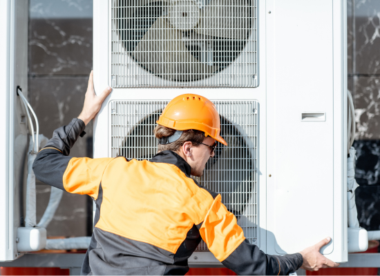 technician performing a heat pump replacement - lifting a double heat pump system