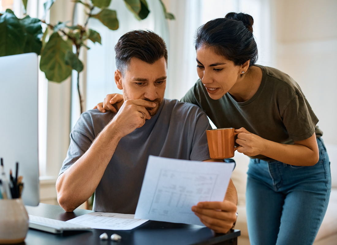 A couple reviews their energy bill looking concerned