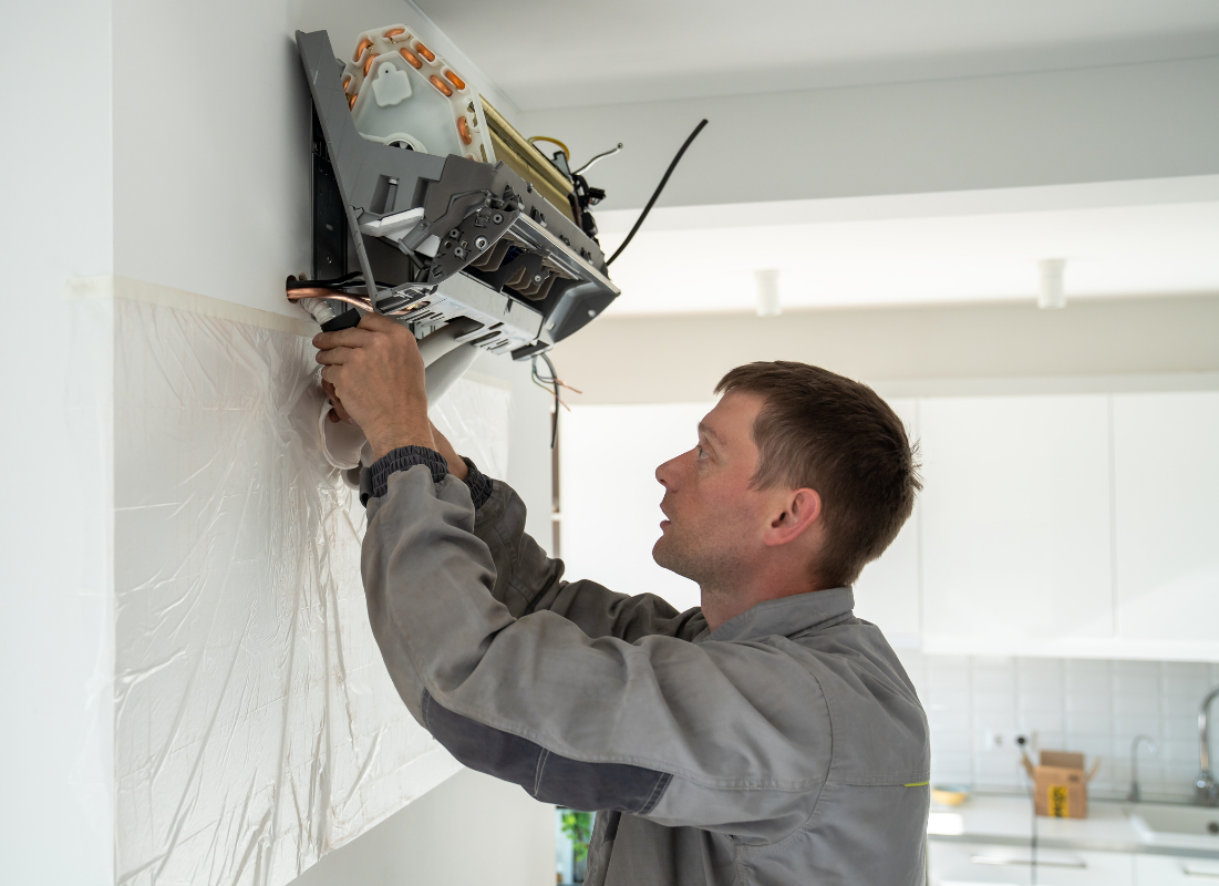 Denver Heat Pump Pro technician working on indoor unit of a ductless mini split heat pump installed in Denver.