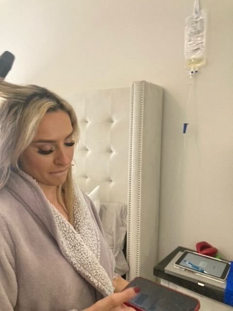 A woman in a bathrobe is looking at her phone