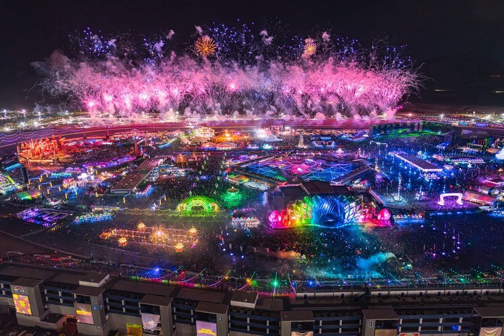 An aerial view of a carnival at night with fireworks.