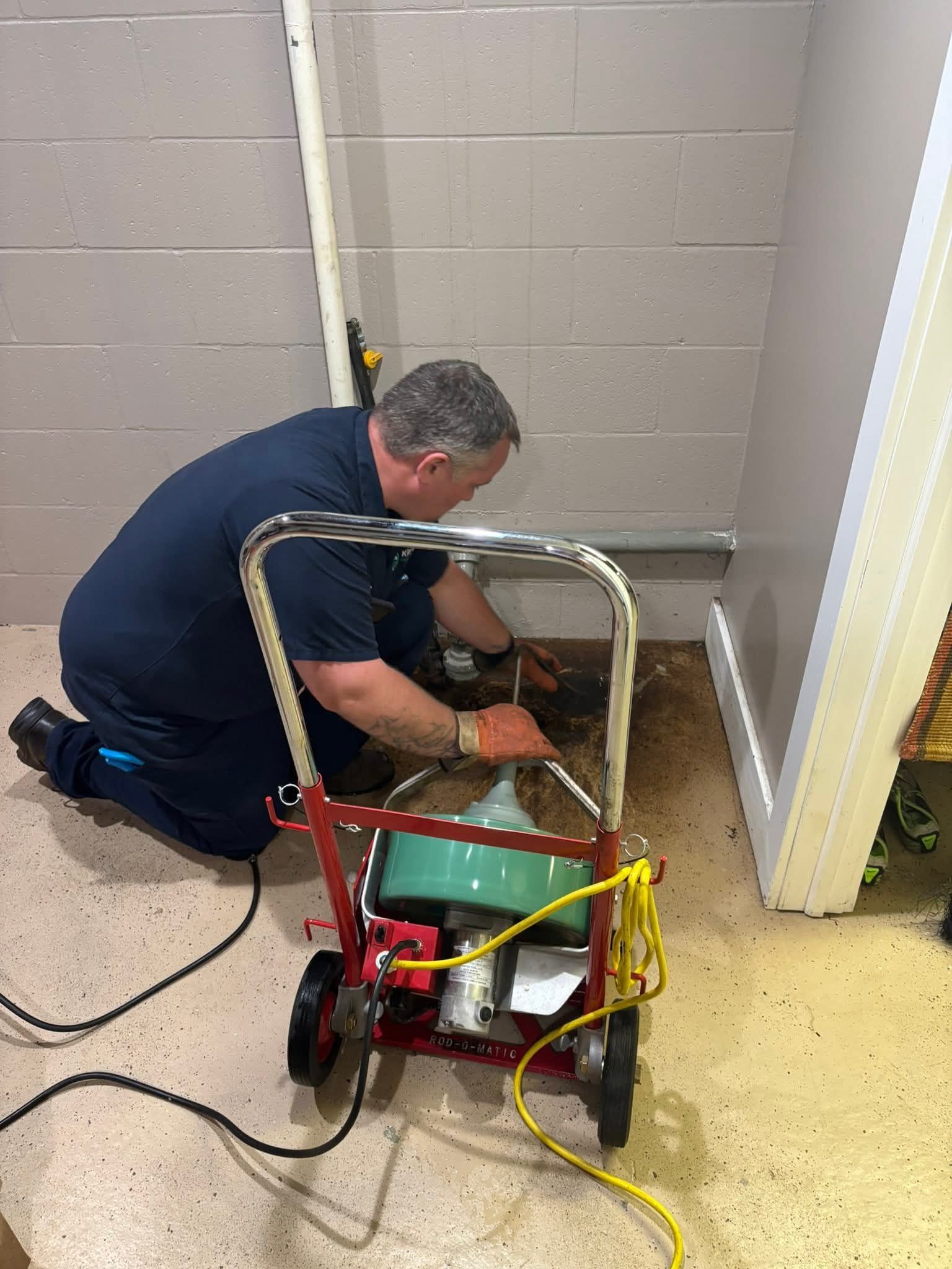 A blue hose is inserted into an open septic tank.