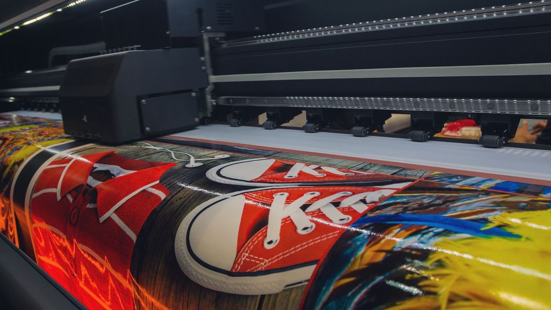 A colorful painting is being printed on a piece of paper.