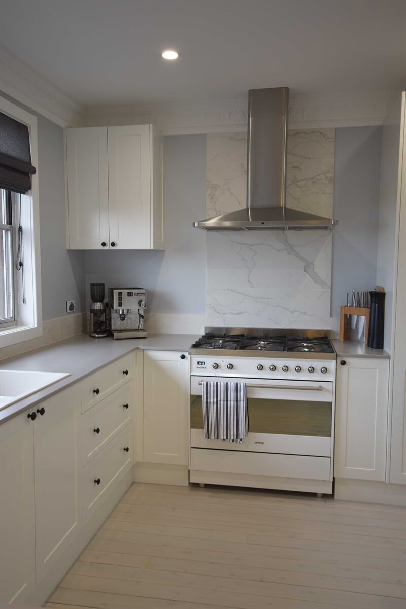 Kitchen with White Cabinets and Stove, Showcasing Bespoke Craftsmanship by Groves Joinery — Custom Cabinetry in Redhead, NSW