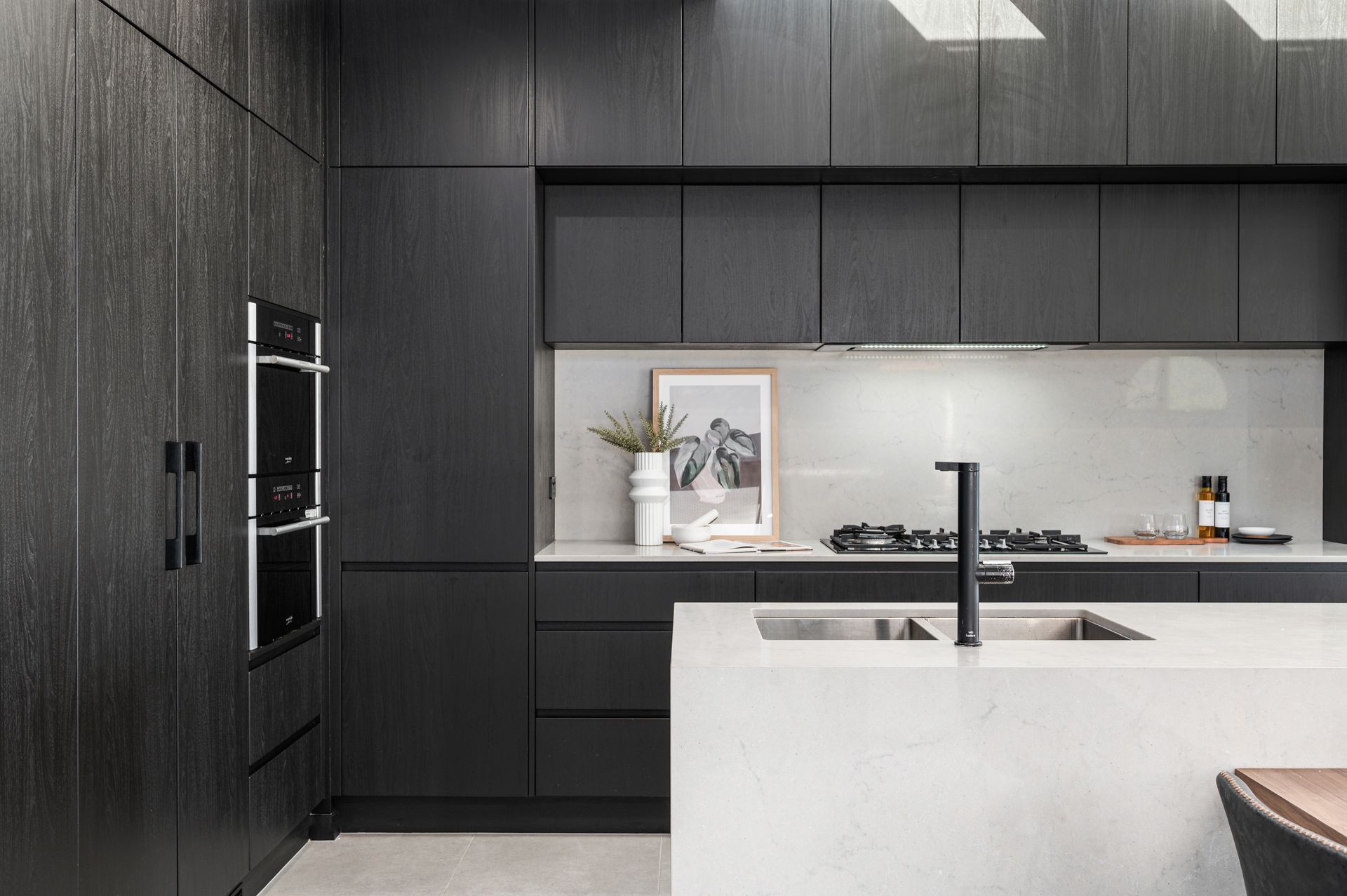 Modern kitchen with black cabinetry and white countertop island - Groves Joinery NSW