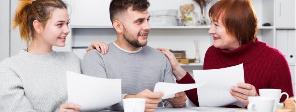 A family is sitting at a table looking at estate planning documents.