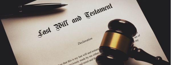 A gavel is sitting on top of a last will and testament