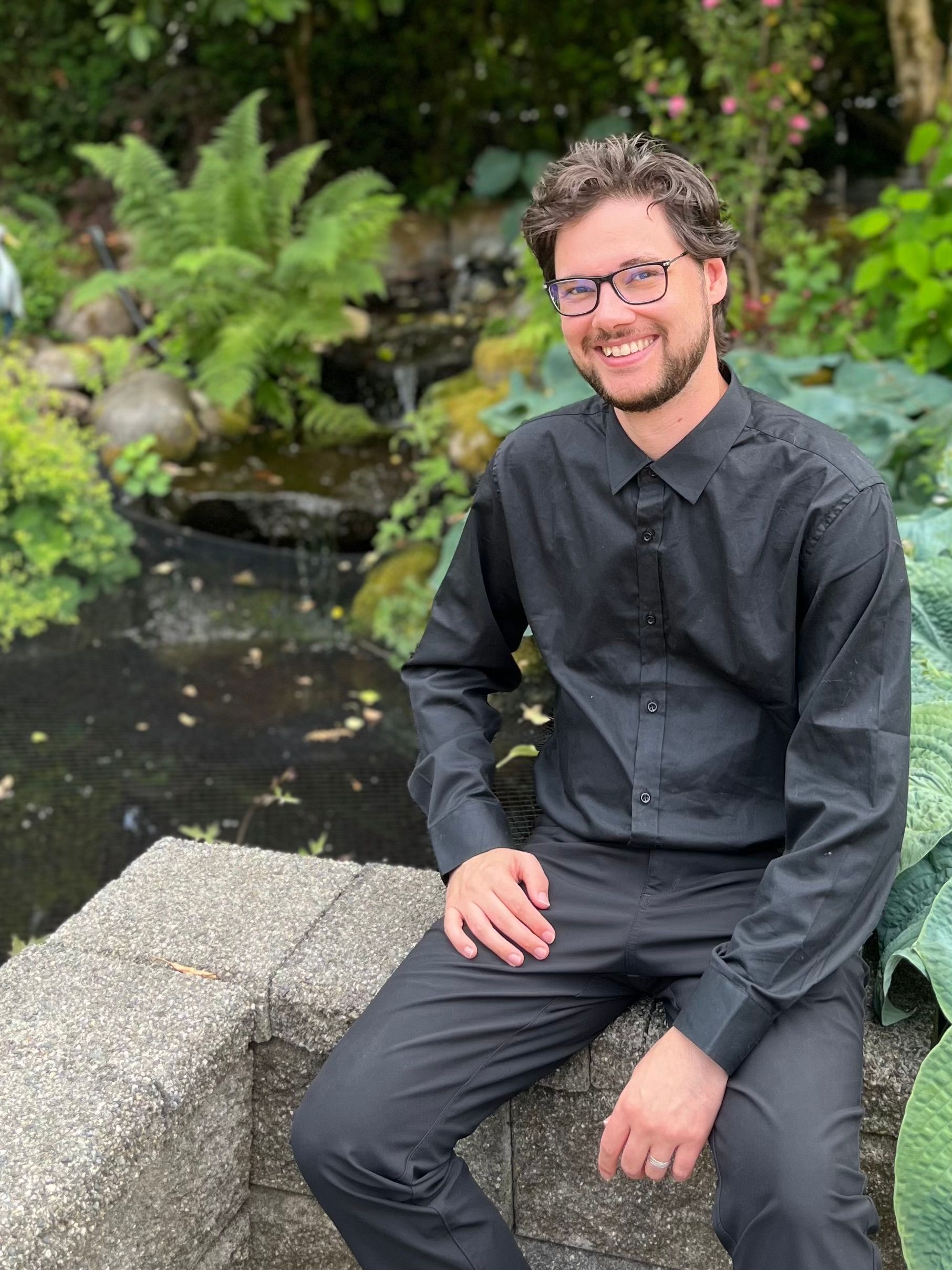 Cole Marton sitting outside by a pond near Kanaka Creek, in Maple Ridge, BC