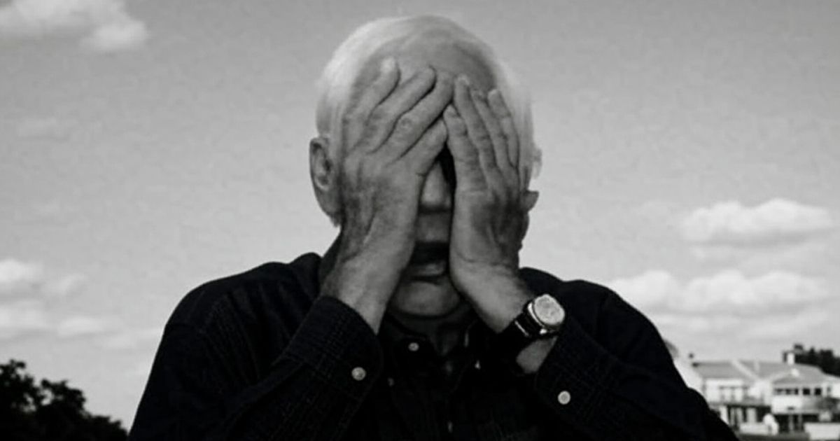 man with hands over his eyes