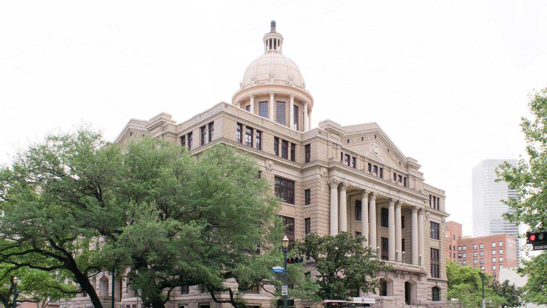 A large building with a dome on top of it is surrounded by trees.