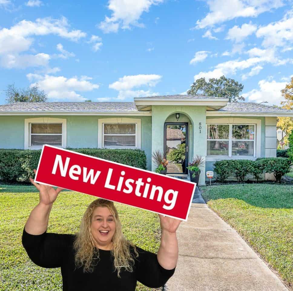 Photo of Edna Wilson holding a New Listing sign