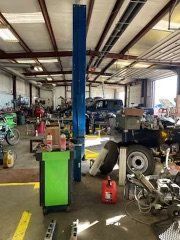 A large garage filled with lots of cars and tools.