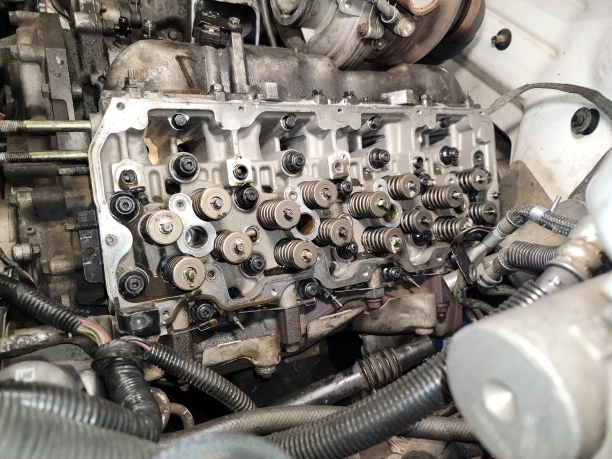 A close up of a car engine with the head removed.