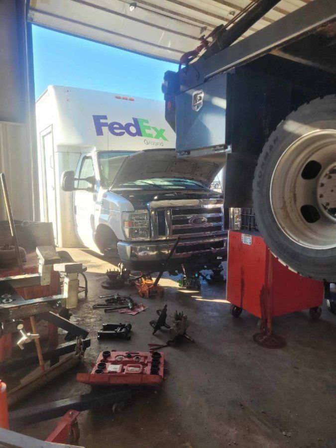 A fedex truck is being repaired in a garage.