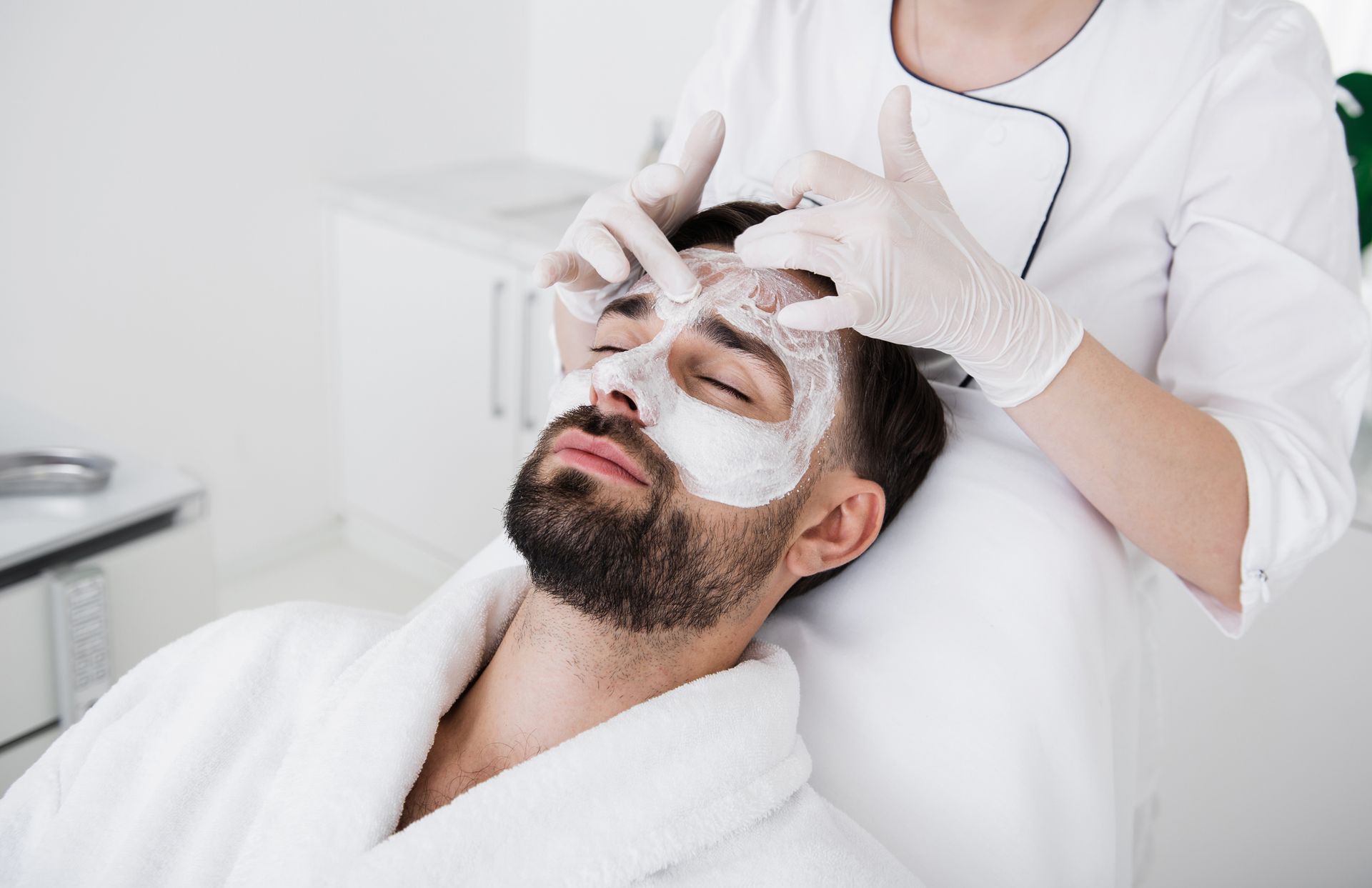 Un uomo si sta sottoponendo a un trattamento per il viso in un salone di bellezza.