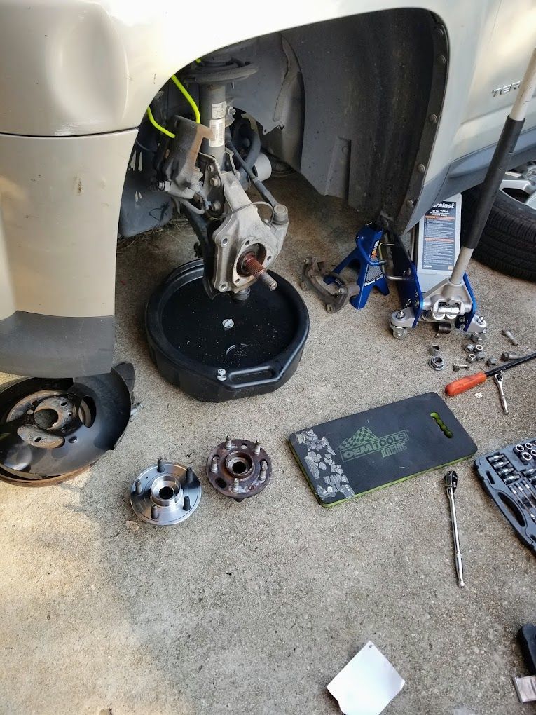 Mechanic using a tool to work on a car engine.