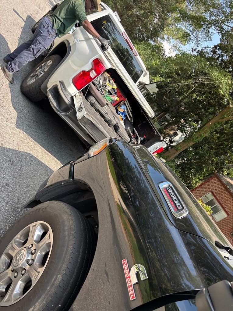 Tires stacked in front of a car raised on a jack; spare tire change.