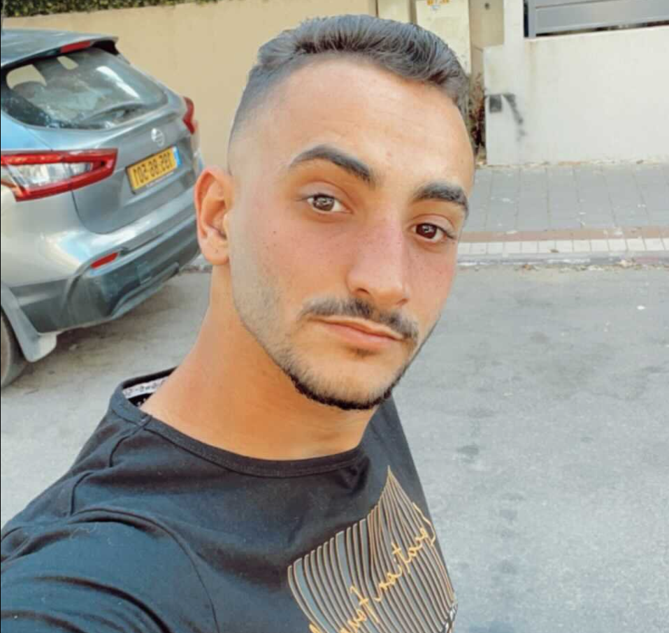 גבר מצלם סלפי עם מכונית ברקע