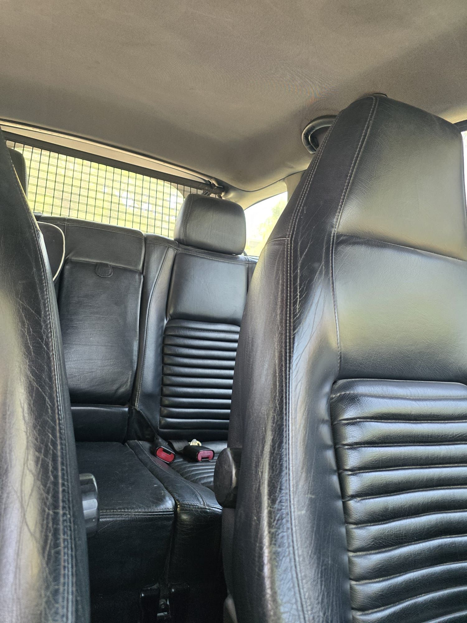 המושב האחורי של מכונית עם מושבי עור שחורים.