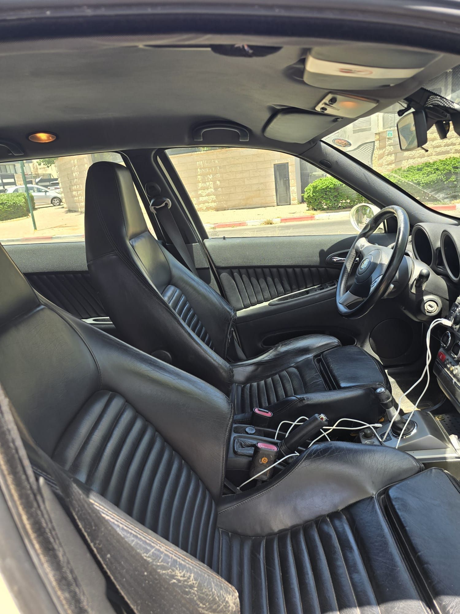 פנים מכונית עם מושבים שחורים והגה.