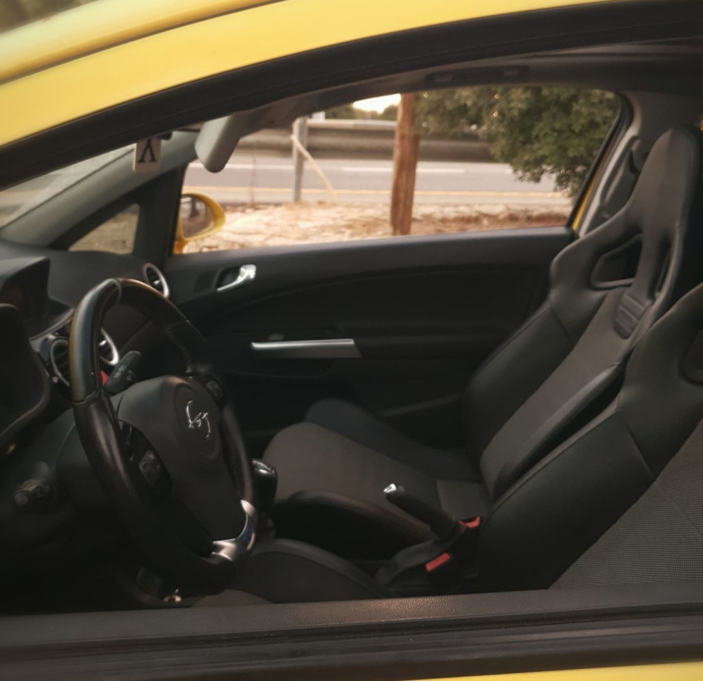 מכונית צהובה עם מושבים שחורים והגה