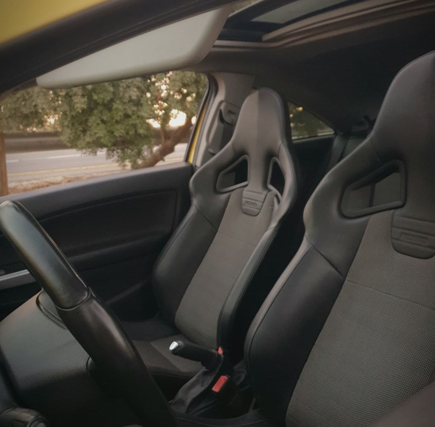 החלק הפנימי של מכונית עם מושב מירוץ וגג שמש