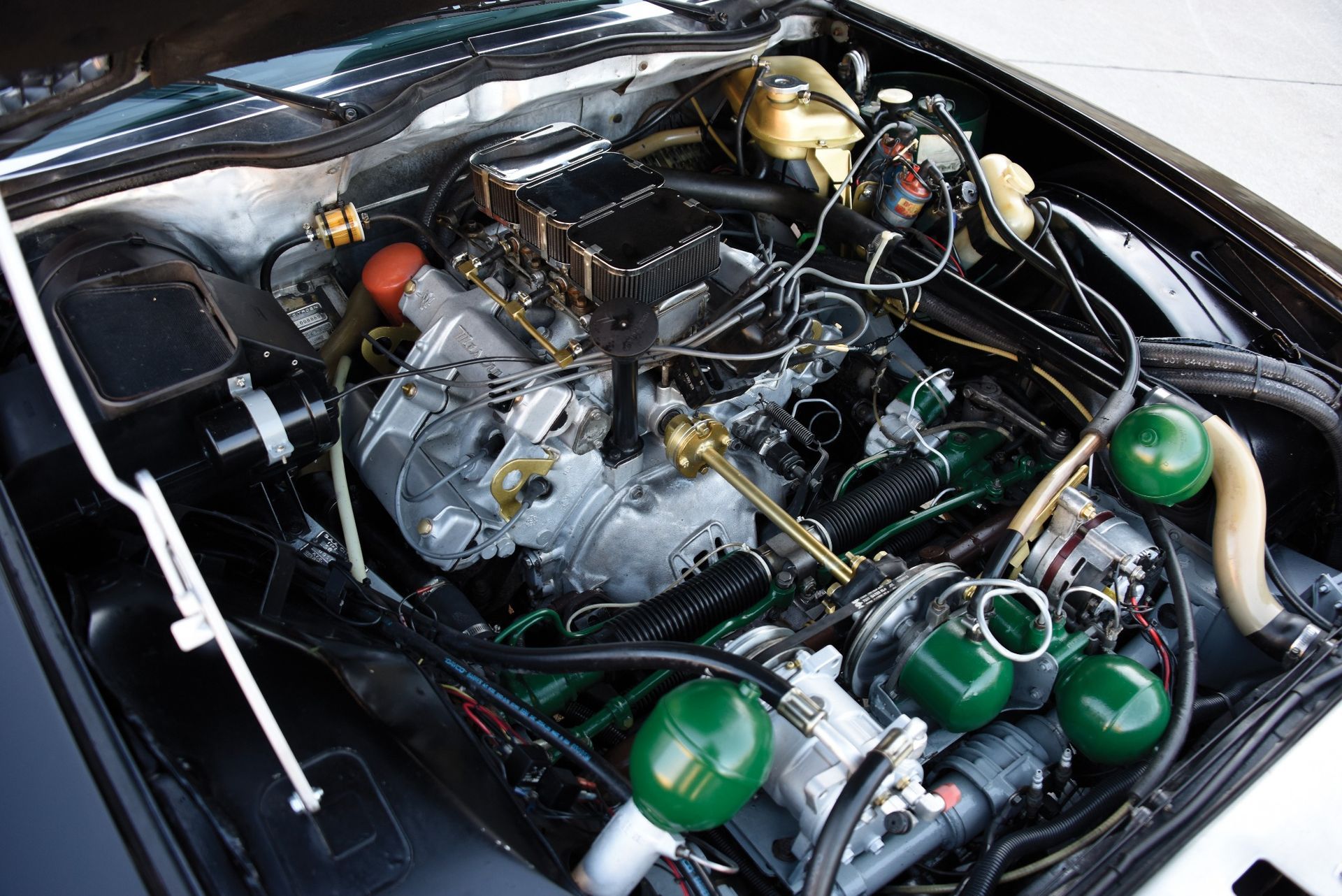 תקריב של מנוע מכונית עם מכסה מנוע פתוח.