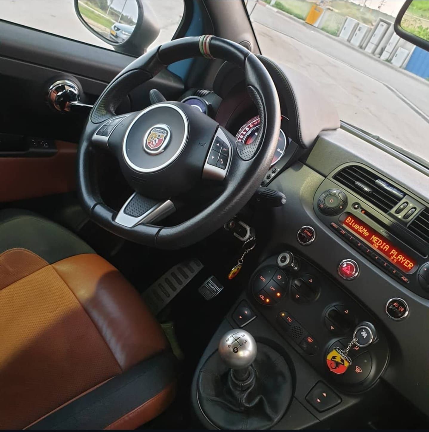 החלק הפנימי של מכונית עם הגה שעליו כתוב 'fiat'