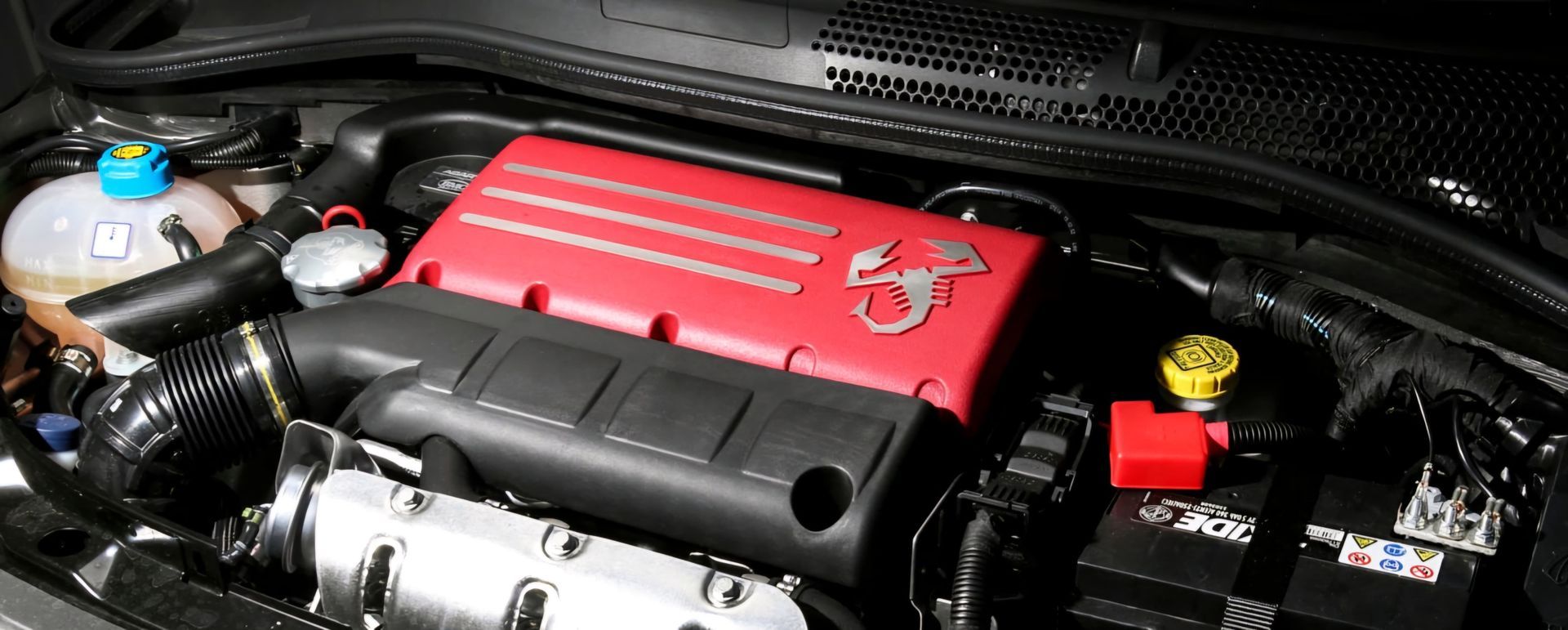 תקריב של מנוע מכונית עם מכסה אדום