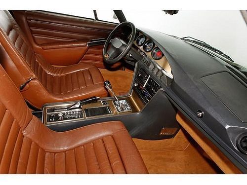 פנים מכונית עם מושבי עור חומים ולוח מחוונים שחור